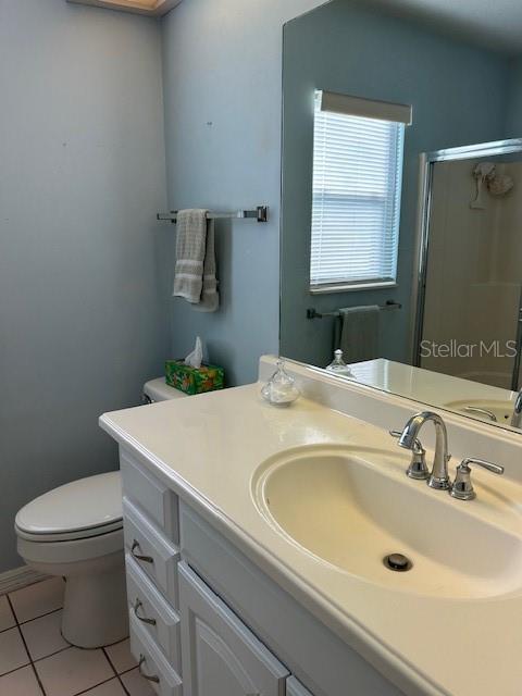 full bath featuring toilet, a shower stall, tile patterned flooring, and vanity