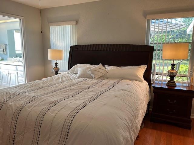 bedroom with wood finished floors and a sink