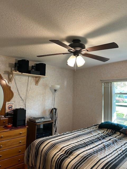 bedroom featuring a textured ceiling and a ceiling fan