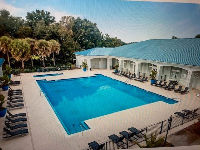 community pool featuring a patio area and fence