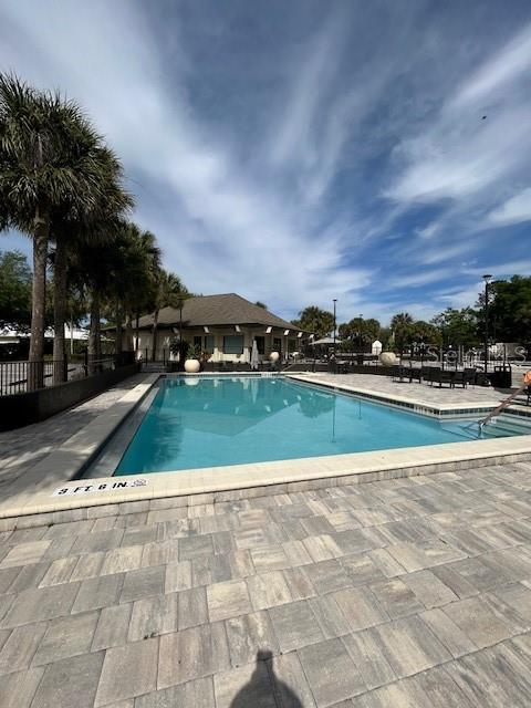 community pool featuring a patio and fence