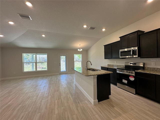 4528 SW 90th Lane Rd, Ocala, FL 34476 - kitchen featuring appliances with stainless steel finishes, open floor plan, a sink, vaulted ceiling, and light stone counters