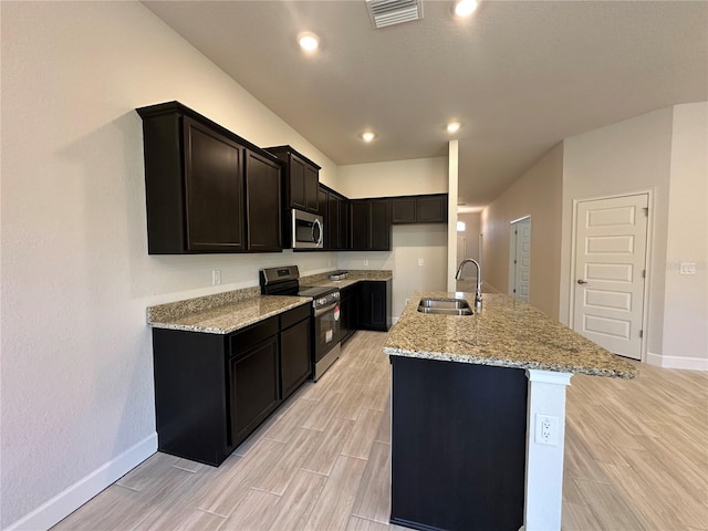 4528 SW 90th Lane Rd, Ocala, FL 34476 - kitchen featuring stainless steel appliances, a sink, baseboards, wood tiled floors, and light stone counters