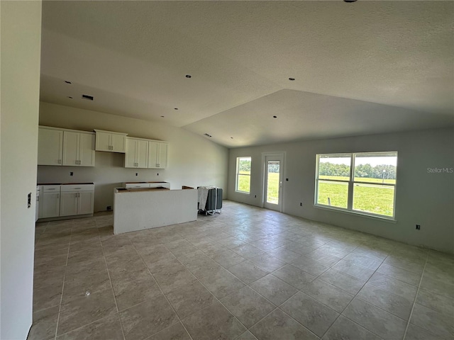 4528 SW 90th Lane Rd, Ocala, FL 34476 - kitchen featuring open floor plan, lofted ceiling, a kitchen island, white cabinets, and light tile patterned flooring