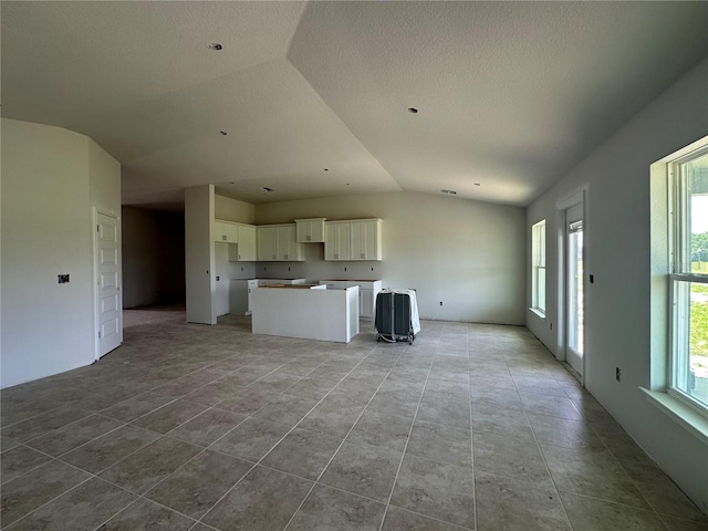 4528 SW 90th Lane Rd, Ocala, FL 34476 - unfurnished living room with vaulted ceiling, tile patterned flooring, and a textured ceiling