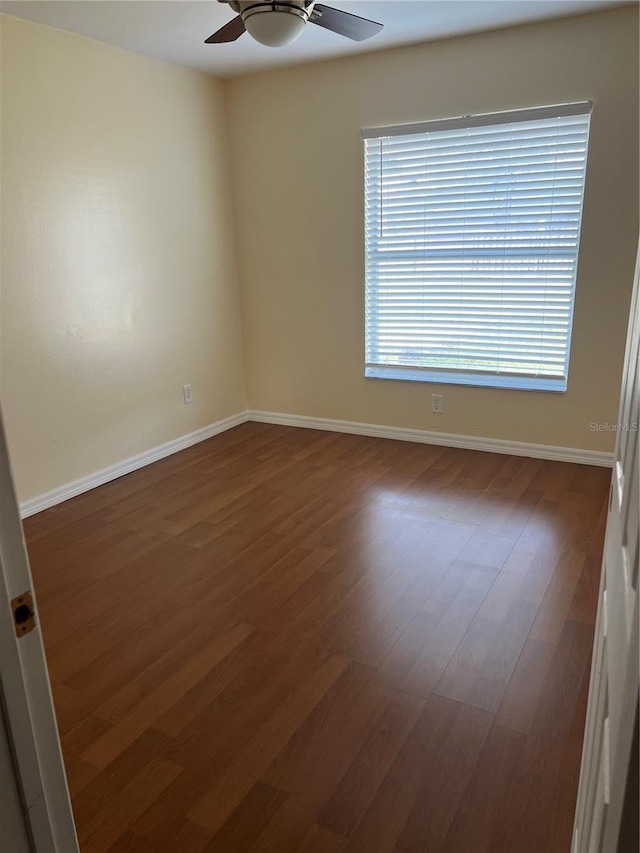 unfurnished room with baseboards, wood finished floors, and a ceiling fan