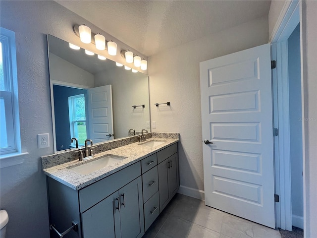 4498 SW 90th Lane Rd, Ocala, FL 34476 - bathroom featuring double vanity, tile patterned floors, a textured ceiling, a textured wall, and baseboards