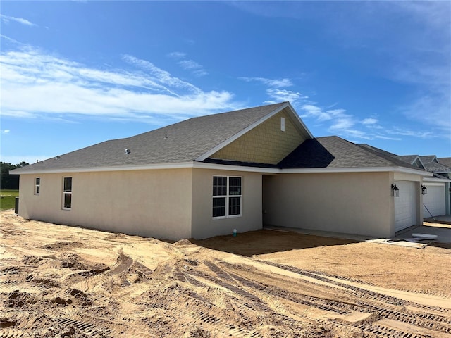 4498 SW 90th Lane Rd, Ocala, FL 34476 - back of property featuring an attached garage, stucco siding, and a shingled roof