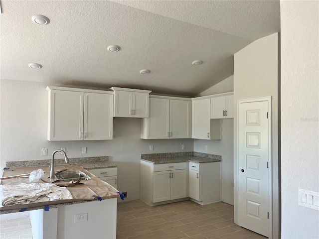 4498 SW 90th Lane Rd, Ocala, FL 34476 - kitchen featuring a peninsula, a textured ceiling, white cabinets, vaulted ceiling, and wood tiled floors