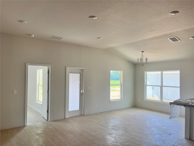 4498 SW 90th Lane Rd, Ocala, FL 34476 - unfurnished living room featuring light wood finished floors, a chandelier, lofted ceiling, and a textured ceiling