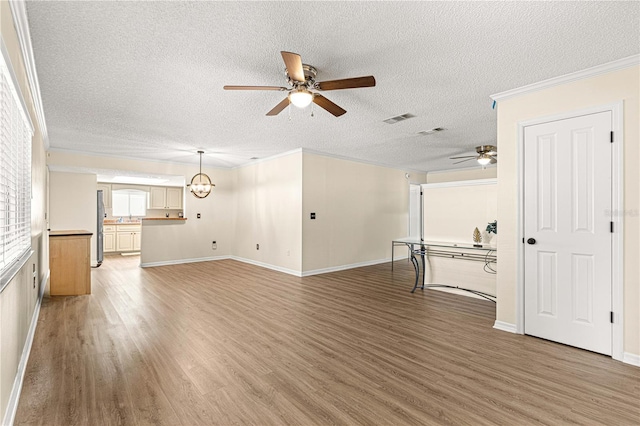 10980 SW 62nd Avenue Rd, Ocala, FL 34476 - unfurnished living room featuring light wood finished floors, visible vents, a ceiling fan, and ornamental molding