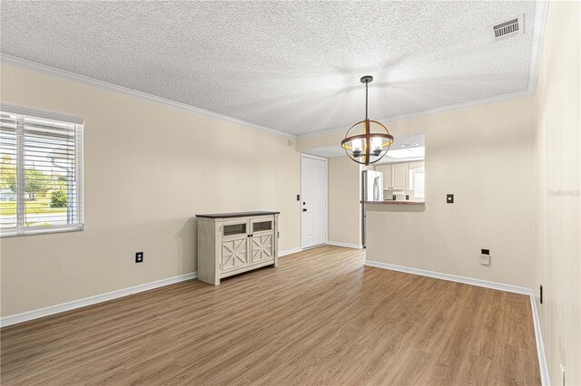 10980 SW 62nd Avenue Rd, Ocala, FL 34476 - spare room with visible vents, a chandelier, ornamental molding, and light wood finished floors