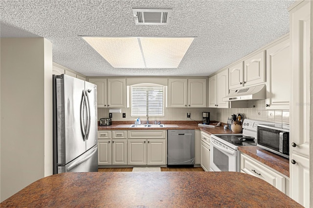 10980 SW 62nd Avenue Rd, Ocala, FL 34476 - kitchen featuring under cabinet range hood, stainless steel appliances, dark countertops, and visible vents