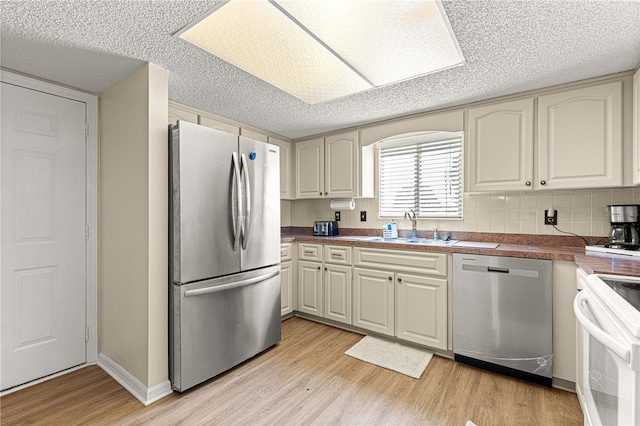 10980 SW 62nd Avenue Rd, Ocala, FL 34476 - kitchen with decorative backsplash, stainless steel appliances, light wood-style floors, a textured ceiling, and a sink