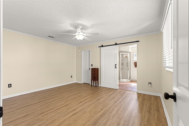 10980 SW 62nd Avenue Rd, Ocala, FL 34476 - unfurnished bedroom featuring visible vents, baseboards, light wood-type flooring, a barn door, and ornamental molding
