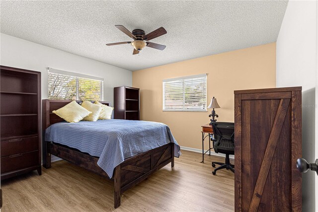 10980 SW 62nd Avenue Rd, Ocala, FL 34476 - bedroom featuring baseboards, light wood-style flooring, a textured ceiling, and a ceiling fan