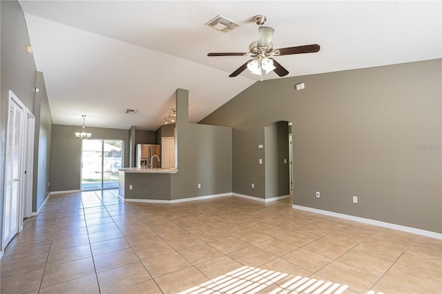 unfurnished living room with light tile patterned floors, visible vents, baseboards, lofted ceiling, and ceiling fan with notable chandelier