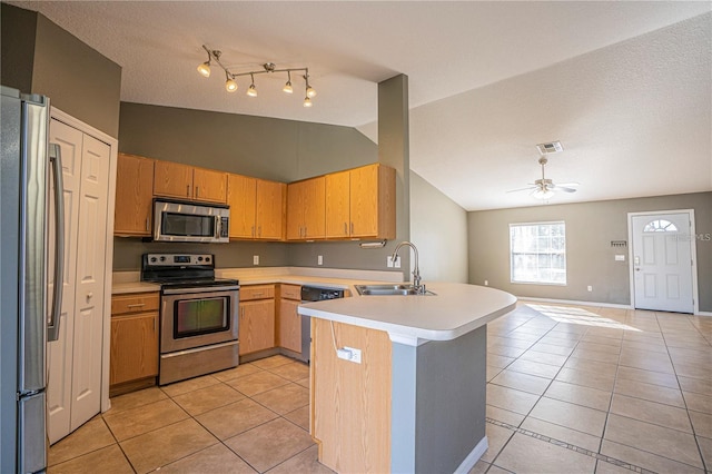 kitchen with visible vents, light tile patterned floors, appliances with stainless steel finishes, a peninsula, and a sink