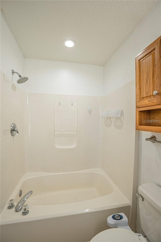 full bathroom featuring a textured ceiling, toilet, and shower / bath combination