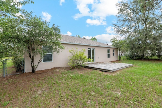 9 Hemlock Run, Ocala, FL 34472 - rear view of property featuring stucco siding, a wooden deck, and a gate