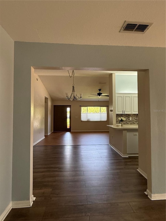 9090 SE 135th Loop, Summerfield, FL 34491 - unfurnished living room with dark wood-type flooring, a chandelier, baseboards, and ceiling fan