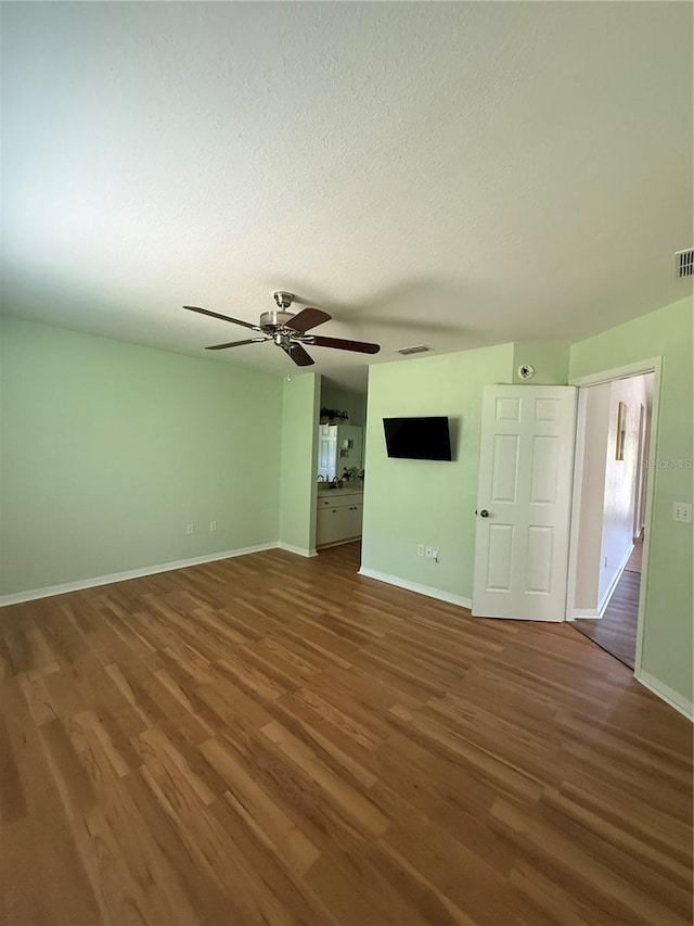 9090 SE 135th Loop, Summerfield, FL 34491 - spare room with wood finished floors, baseboards, a ceiling fan, and a textured ceiling