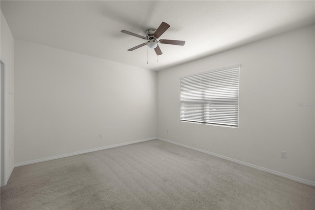 unfurnished room featuring baseboards, a ceiling fan, and carpet