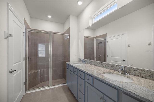 full bath featuring a shower stall, a sink, and double vanity