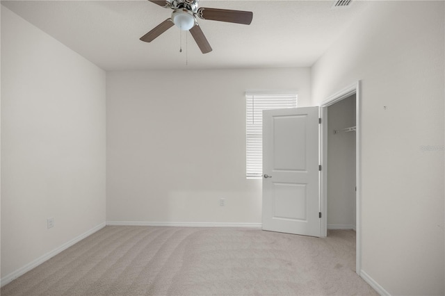 empty room featuring light colored carpet, ceiling fan, and baseboards