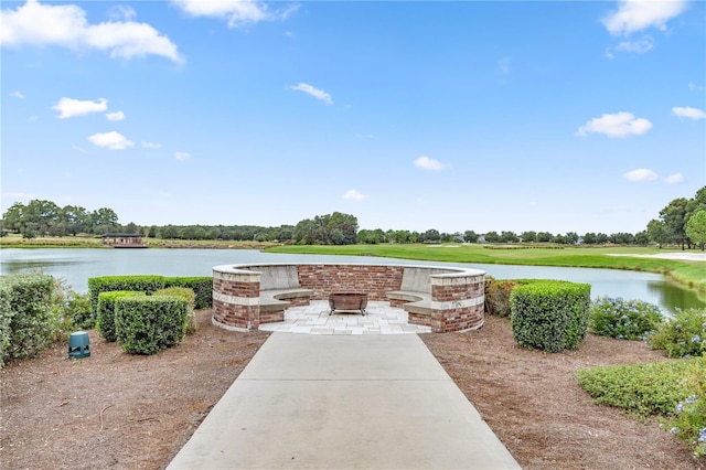 view of patio with a fire pit and a water view