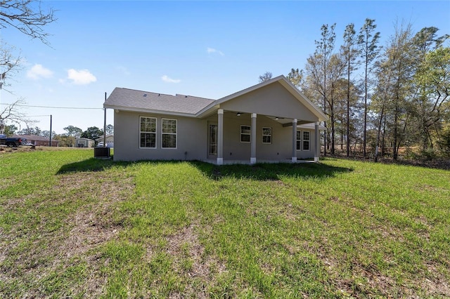 760 NE 152nd Ter, Williston, FL 32696 - rear view of house featuring central air condition unit, stucco siding, a lawn, and a ceiling fan