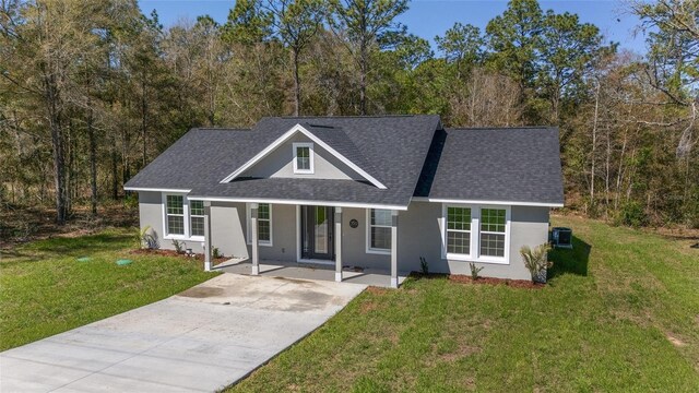 760 NE 152nd Ter, Williston, FL 32696 - view of front facade with stucco siding, roof with shingles, concrete driveway, and a front yard