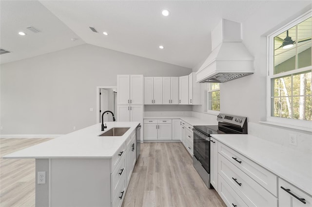 760 NE 152nd Ter, Williston, FL 32696 - kitchen with a center island with sink, custom range hood, a sink, stainless steel appliances, and light countertops