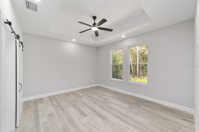 760 NE 152nd Ter, Williston, FL 32696 - unfurnished room featuring baseboards, a raised ceiling, a barn door, and a ceiling fan