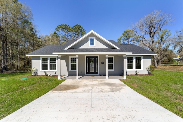 760 NE 152nd Ter, Williston, FL 32696 - view of front of property featuring a front lawn, roof with shingles, covered porch, stucco siding, and driveway