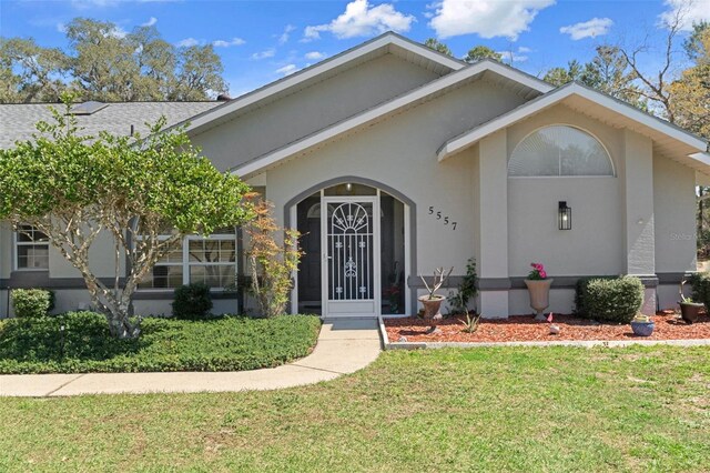 5557 N Sierra Ter, Beverly Hills, FL 34465 - view of front facade featuring a yard and stucco siding