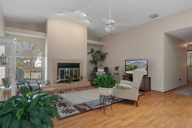 5557 N Sierra Ter, Beverly Hills, FL 34465 - living room featuring vaulted ceiling, a tiled fireplace, a ceiling fan, visible vents, and wood finished floors