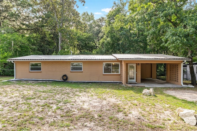 3910 SE 14th Ter, Gainesville, FL 32641 - view of front of house with a carport, a metal roof, a front yard, and driveway