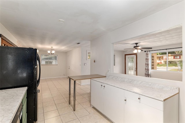 3910 SE 14th Ter, Gainesville, FL 32641 - kitchen featuring freestanding refrigerator, light countertops, light tile patterned floors, a chandelier, and white cabinets