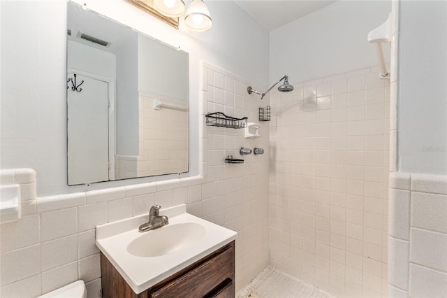 3910 SE 14th Ter, Gainesville, FL 32641 - bathroom with vanity, a tile shower, and tile walls