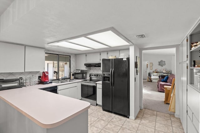 kitchen featuring visible vents, under cabinet range hood, light countertops, a peninsula, and black appliances