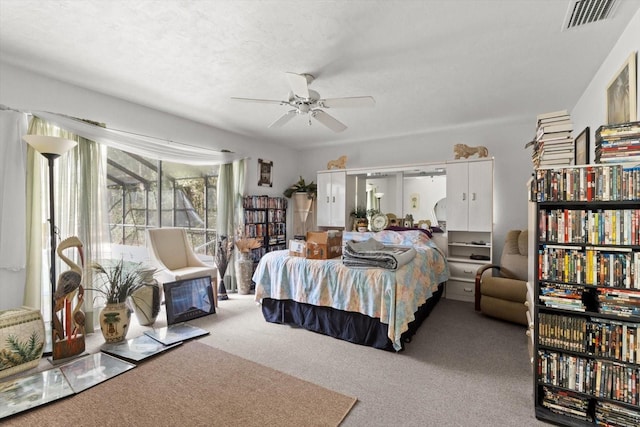 bedroom featuring a ceiling fan, visible vents, carpet floors, and a textured ceiling
