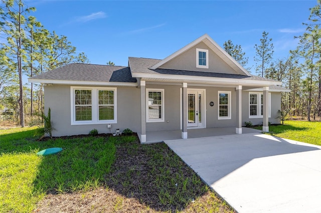 791 NE 150th Ave, Williston, FL 32696 - view of front facade featuring a porch, a front lawn, roof with shingles, and stucco siding