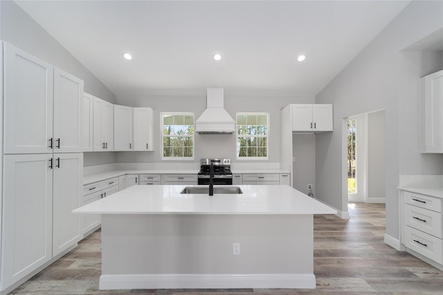 791 NE 150th Ave, Williston, FL 32696 - kitchen featuring a center island with sink, premium range hood, lofted ceiling, a sink, and white cabinetry
