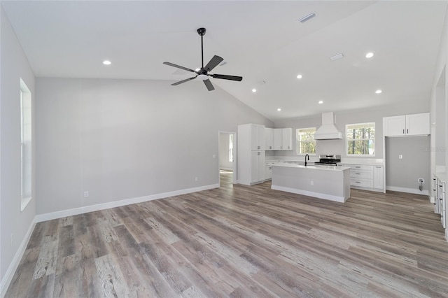 791 NE 150th Ave, Williston, FL 32696 - unfurnished living room featuring baseboards, lofted ceiling, a ceiling fan, and light wood finished floors