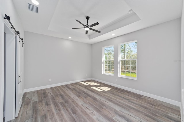 791 NE 150th Ave, Williston, FL 32696 - spare room featuring visible vents, a raised ceiling, baseboards, and a barn door