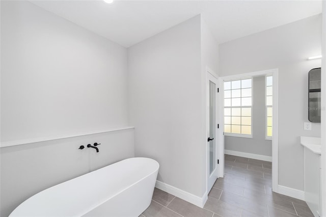 791 NE 150th Ave, Williston, FL 32696 - bathroom featuring tile patterned floors, a freestanding tub, baseboards, and vanity