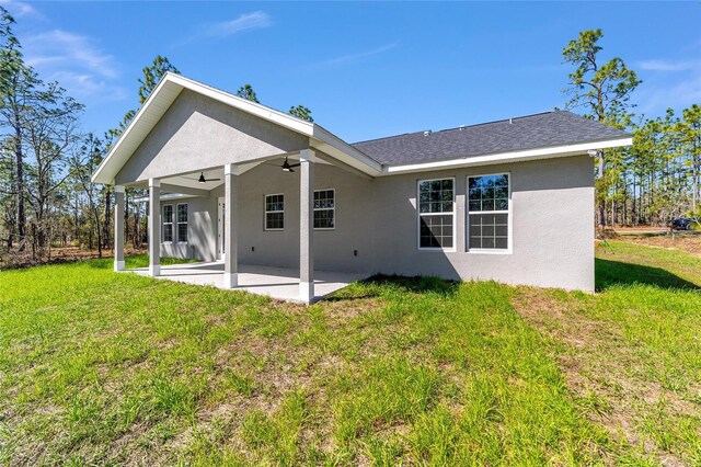 791 NE 150th Ave, Williston, FL 32696 - back of property with ceiling fan, a patio, a lawn, and stucco siding