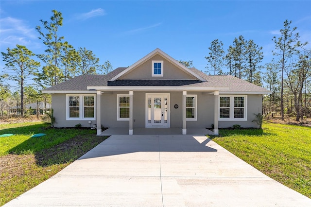791 NE 150th Ave, Williston, FL 32696 - view of front of house with stucco siding, a front yard, and a shingled roof