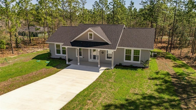 791 NE 150th Ave, Williston, FL 32696 - view of front facade with a front yard, roof with shingles, covered porch, stucco siding, and driveway